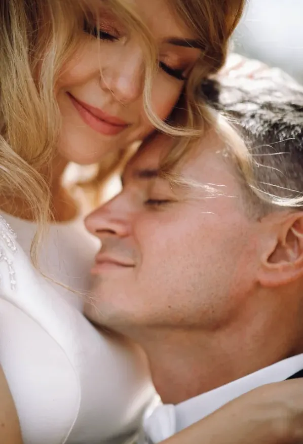 Una pareja sonríe abrazada, frente con frente
