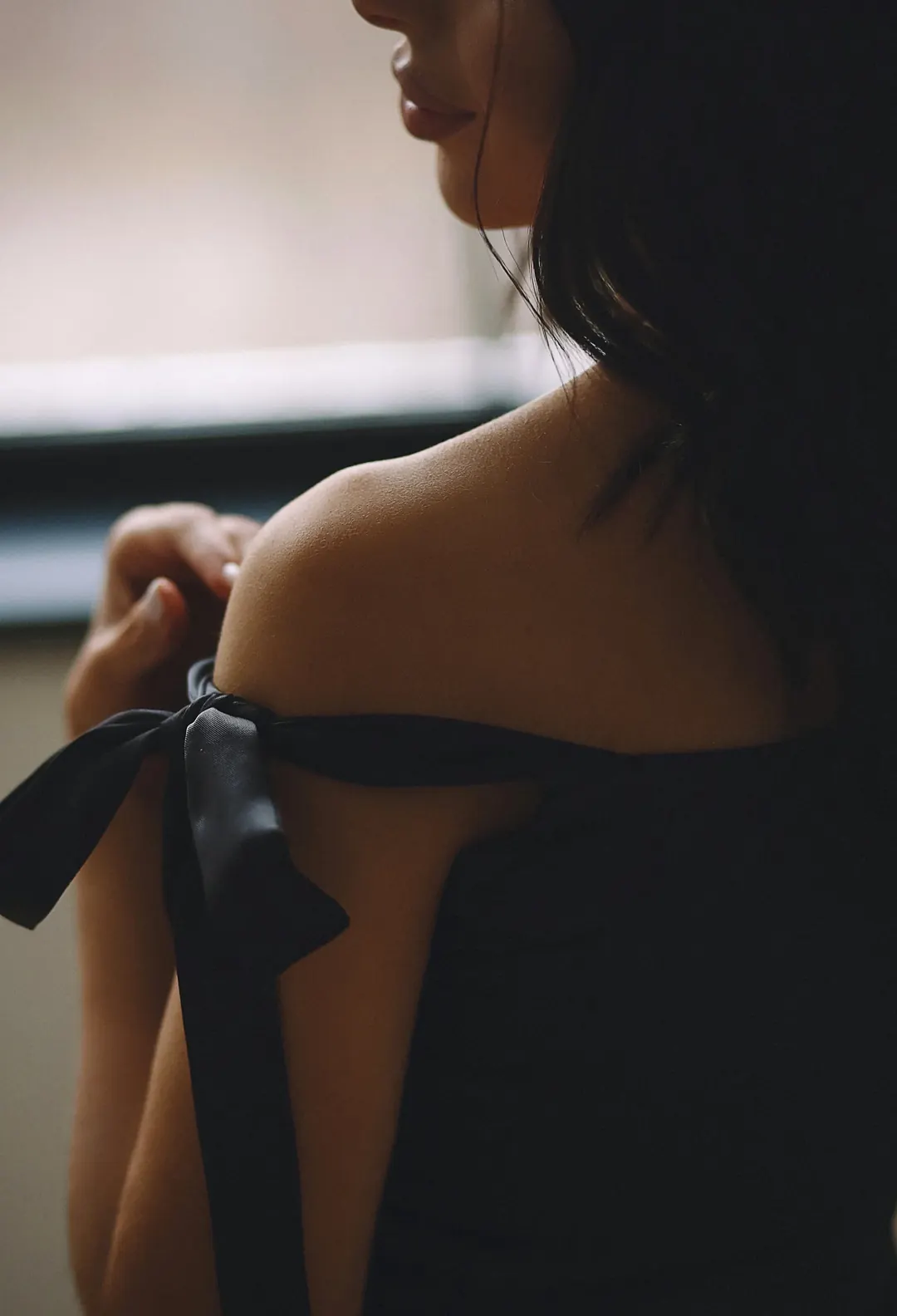 Una mujer de espaldas con un vestido de noche y un lazo negro